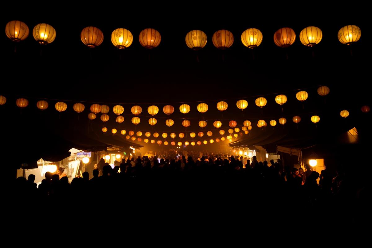 Night-time cultural gathering in Assam lit by hanging lanterns