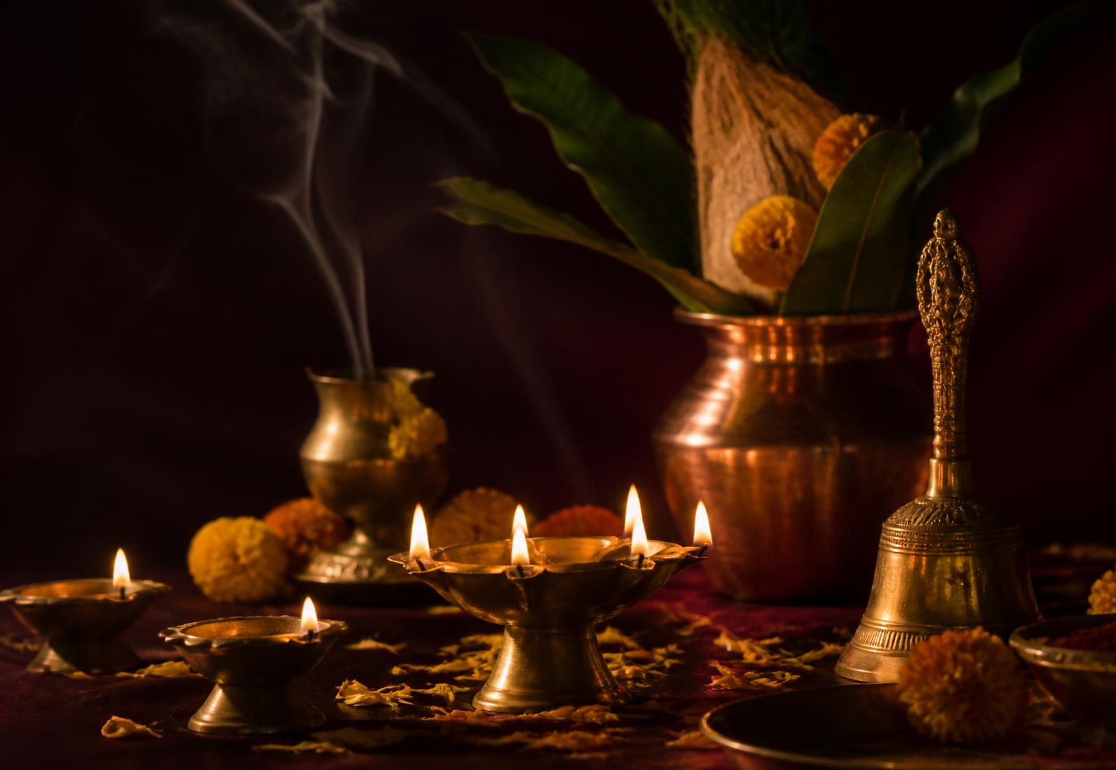 Brass oil lamps, copper kalash and marigold petals arranged for a traditional observance in Mayong, Assam